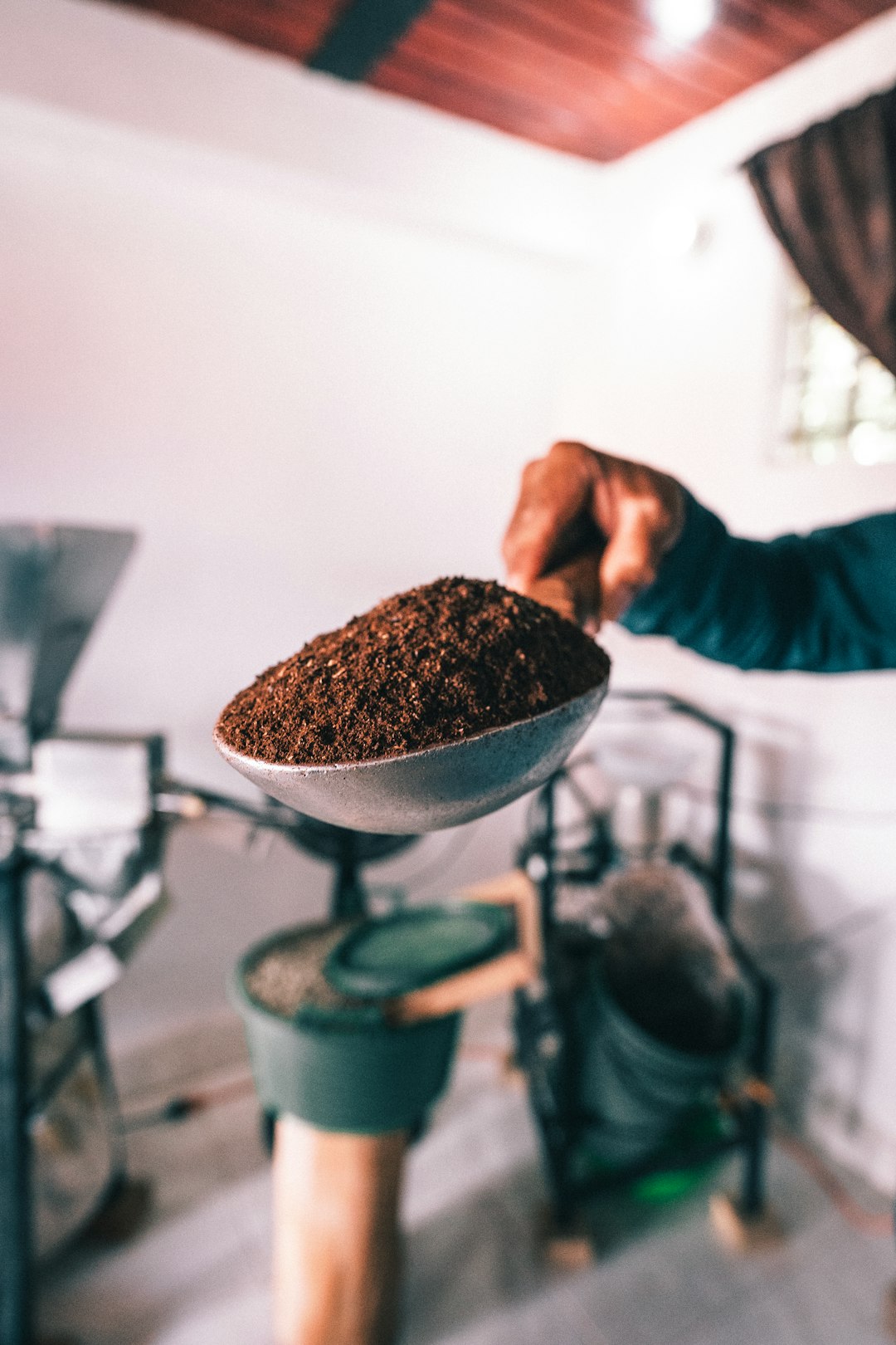 A person holding a bowl of ground coffee